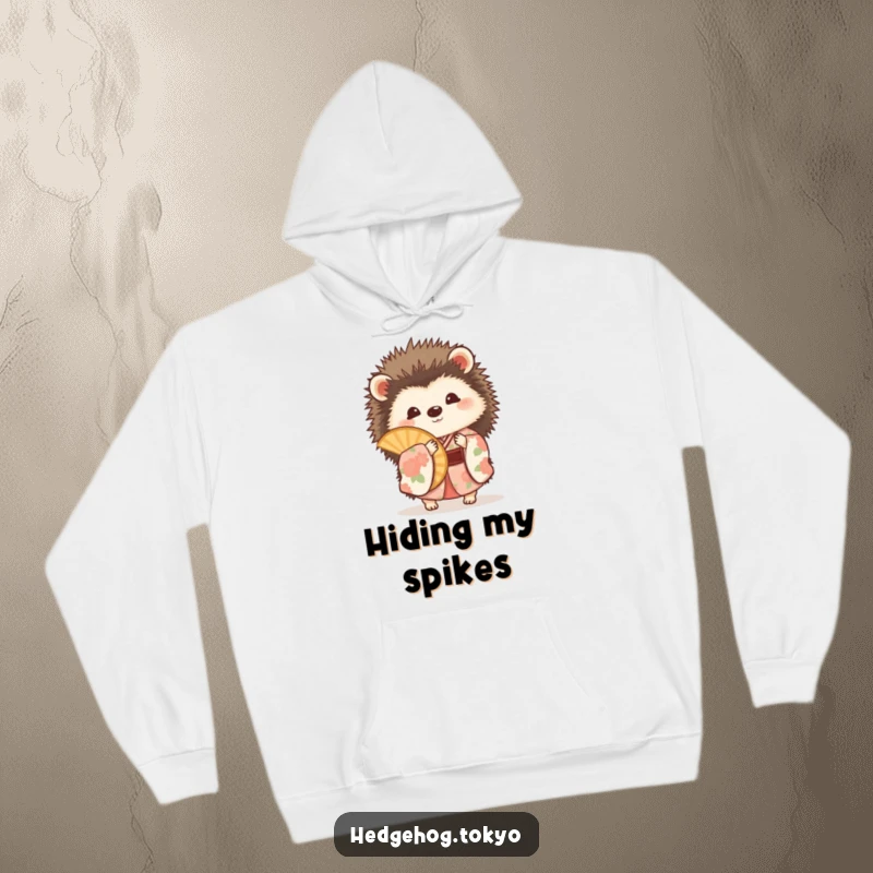 Funny hedgehog wearing a floral kimono, playfully peeking around a fan, depicted on a warm and cozy hoodie.