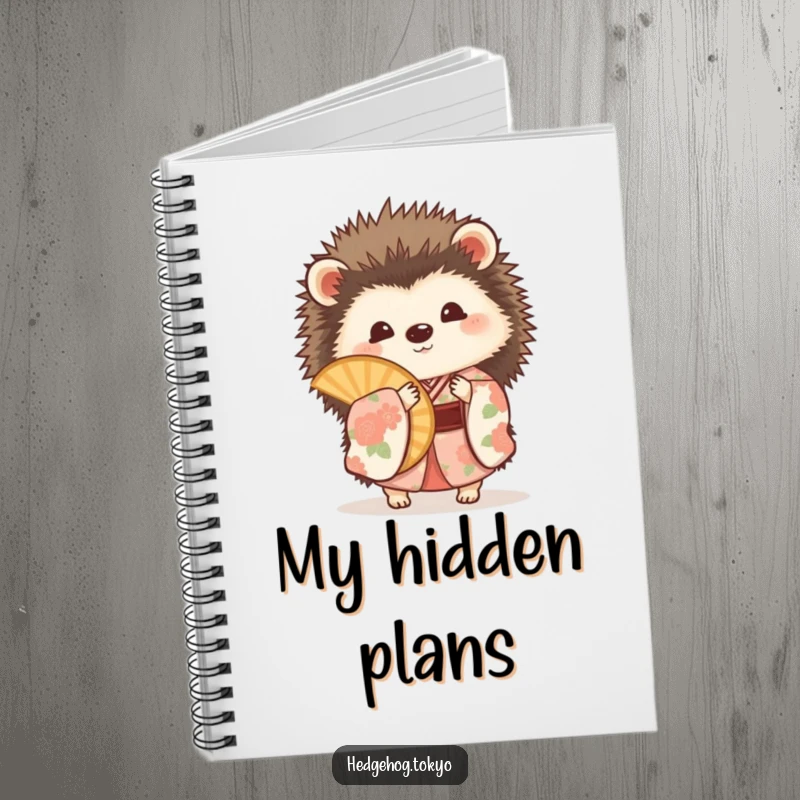 Funny hedgehog in a floral kimono, playfully peeking from behind a fan on the cover of a stylish notebook.